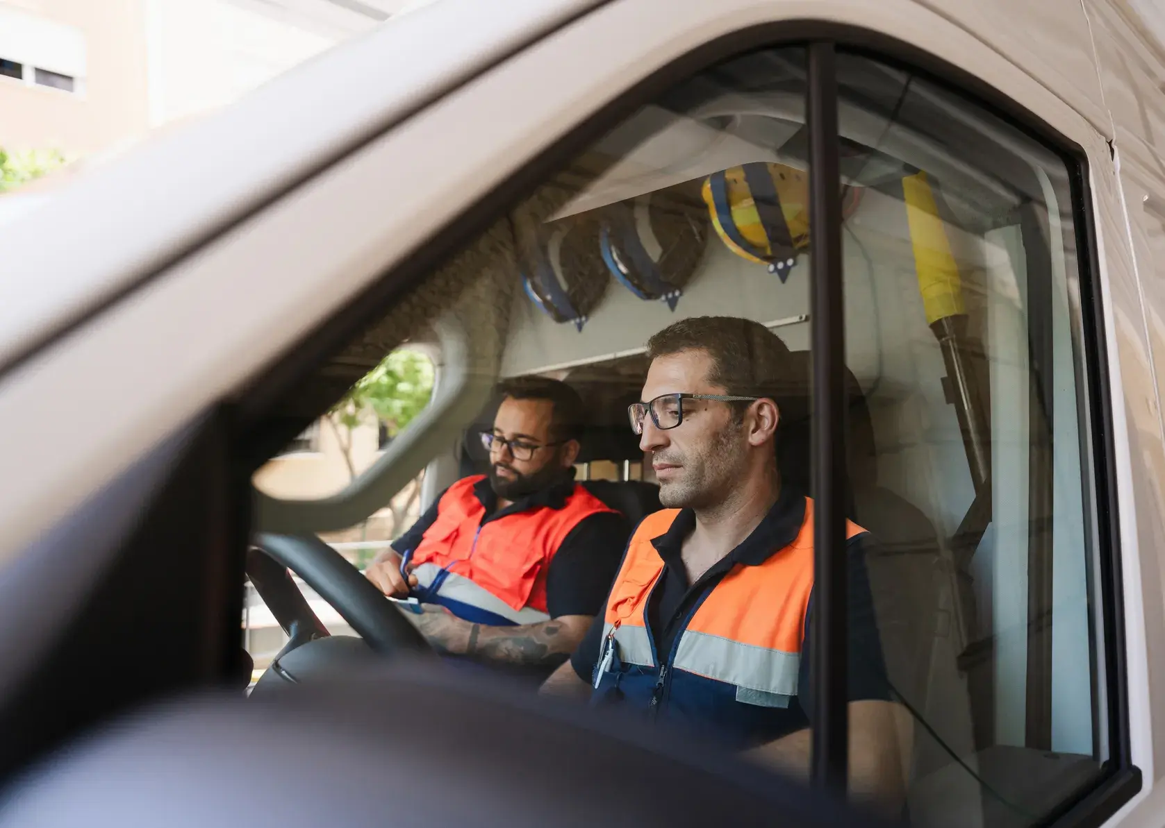Worker in hi-vis vest loading a van at a job site